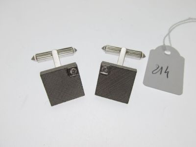 pair of black and silver cufflinks with a price tag