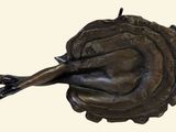 a bronze statue of a woman laying on her stomach