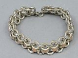 a close up of a chain bracelet on a gray surface
