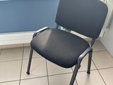 a black chair sitting in front of a window in a room