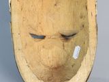 a wooden mask that is on display on the wall