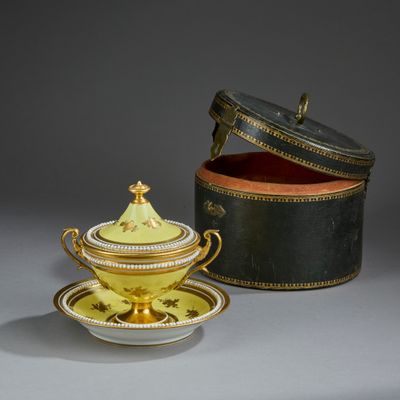 a yellow and black bowl and saucer on a table