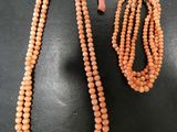 un collier et un bracelet composés de perles de corail sur un fond noir