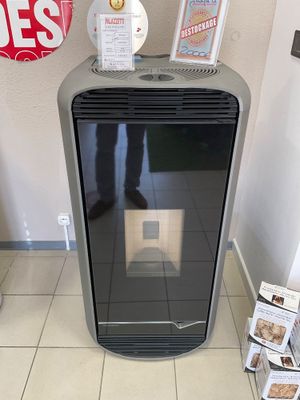 un radiateur noir posé sur un sol carrelé dans une pièce