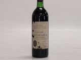 a bottle of red wine sitting on top of a white table