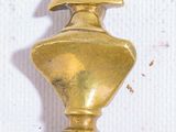 a gold vase with a hat on top of it
