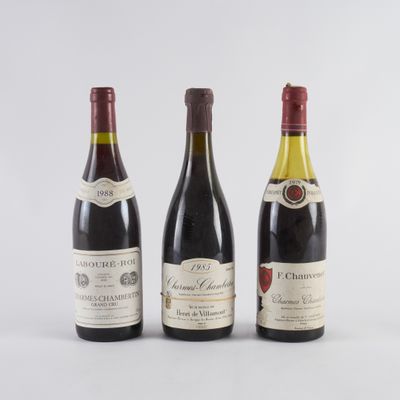 trois bouteilles de vin sont alignées sur une surface blanche
