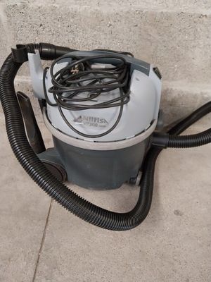 a vacuum that is sitting on the ground next to a wall
