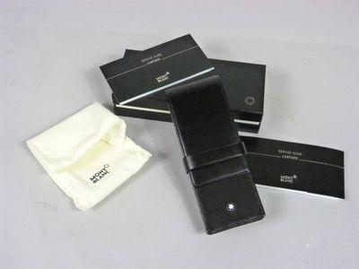 two black leather wallets and a white cloth are on a table