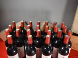 several bottles of red wine are lined up on a table