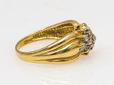 a close up of a gold ring with diamonds on a white surface