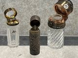 trois bouteilles en verre posées les unes à côté des autres sur une table