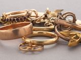 a pile of gold rings and other jewelry on a table