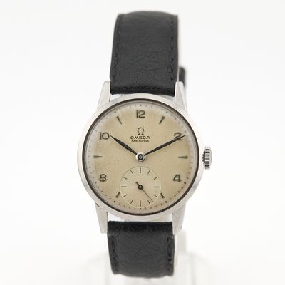 une image représentant une montre argentée et noire posée sur une surface blanche