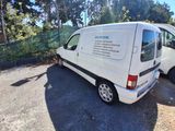 a white van parked in a parking lot with trees in the background