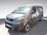 une camionnette grise garée sur un parking près d'un mur blanc