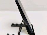 a tablet computer sitting on a stand on a table