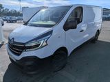 une camionnette blanche garée sur un parking, avec d'autres véhicules en arrière-plan
