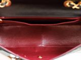 the inside of a black and red purse with a gold handle