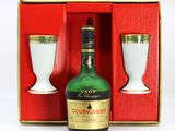 une bouteille d'alcool à côté d'un verre dans une boîte