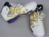 pair of white and yellow sneakers with purple accents on a gray surface