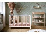 a picture of a baby ' s room with a crib and bookshelf