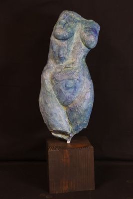 sculpture of a woman sitting on a wooden block