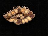 un gros plan d'une broche représentant des fleurs sur fond noir