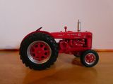 a red toy tractor sitting on a wooden table