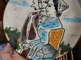 a person holding a plate with a picture of a man and a woman on it