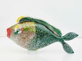 brightly colored glass fish figurine sitting on a white surface