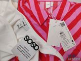 two shirts with tags on them sitting on a table next to each other