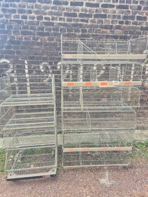 two metal cages are stacked on top of each other in front of a brick wall
