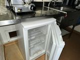 an open refrigerator in a small kitchen with a mixer on the counter