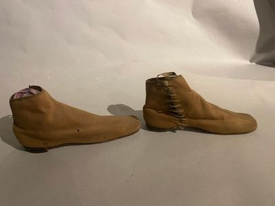 pair of brown sued shoes with laces on them on a white surface