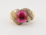 a close up of a gold ring with a pink stone surrounded by diamonds