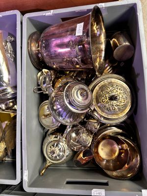 deux bacs remplis d'objets en argent posés sur une table