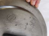 a hand that is holding a metal pan with a handle