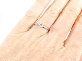 a woman ' s hand with a diamond ring on it
