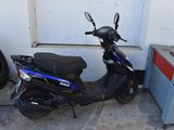 un scooter garé à côté d'un pneu
