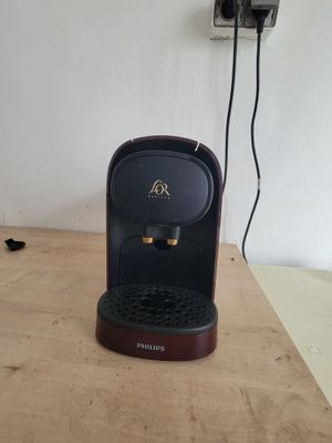 a coffee maker sitting on a wooden table in a room