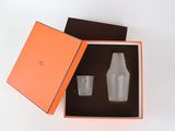 an orange box with two cups inside of it on a white surface