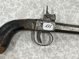 un vieux pistolet muni d'une étiquette, posé sur une table