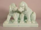 two figurines of dogs sitting on top of a table