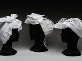 trois têtes de mannequins noires ornées de dentelle blanche et de nœuds