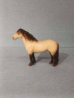 un petit cheval en jouet posé sur une table