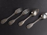 four silver spoons and a fork on a black surface