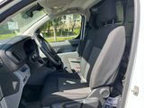 the interior of a white van with black seats and a steering wheel