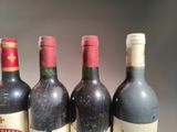 several bottles of wine are lined up on a table