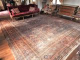 une photo d'un salon avec un grand tapis au sol